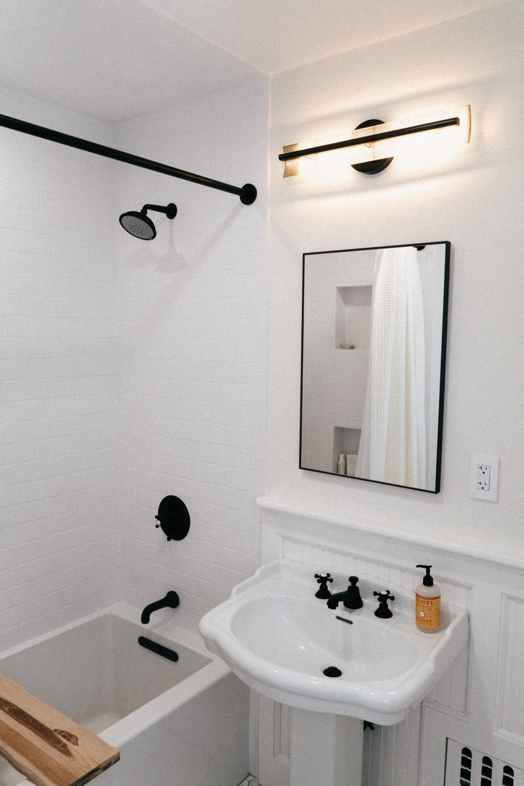 Simply by Simone - Simone Piliero - My Black and White Bathroom Renovation - Finished Photos - Bathtub and Shower - Sink - Sconce #bathroom #home #renovation #bathroomrenovation #diyhome #bathroomtiles #bathroomdecor #bathroomideas #bathroomrenovationideas