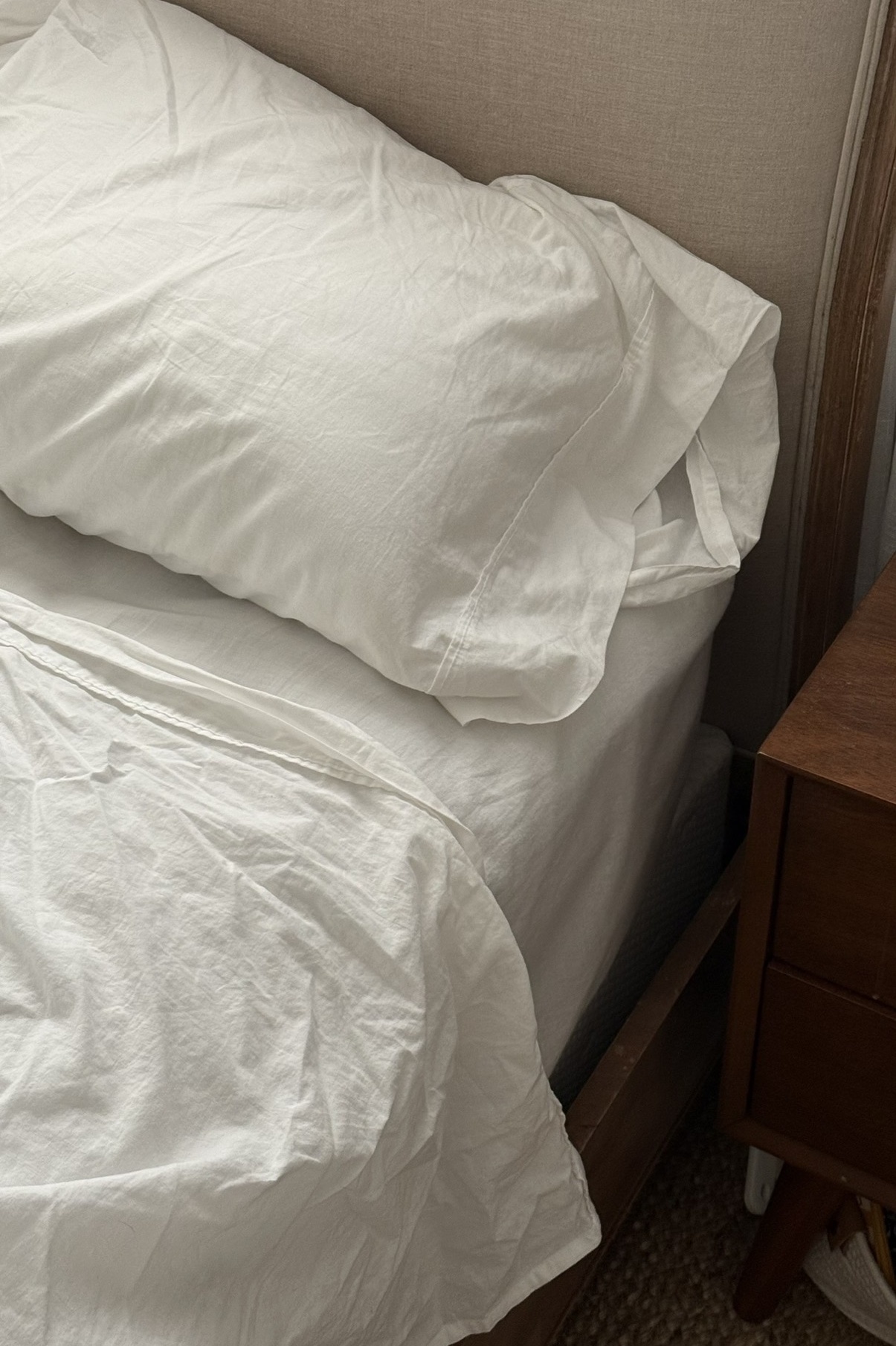 Lane Linen bedding styled with relaxed neutral layers and vintage wood furniture for a breathable, lived-in bedroom look.
